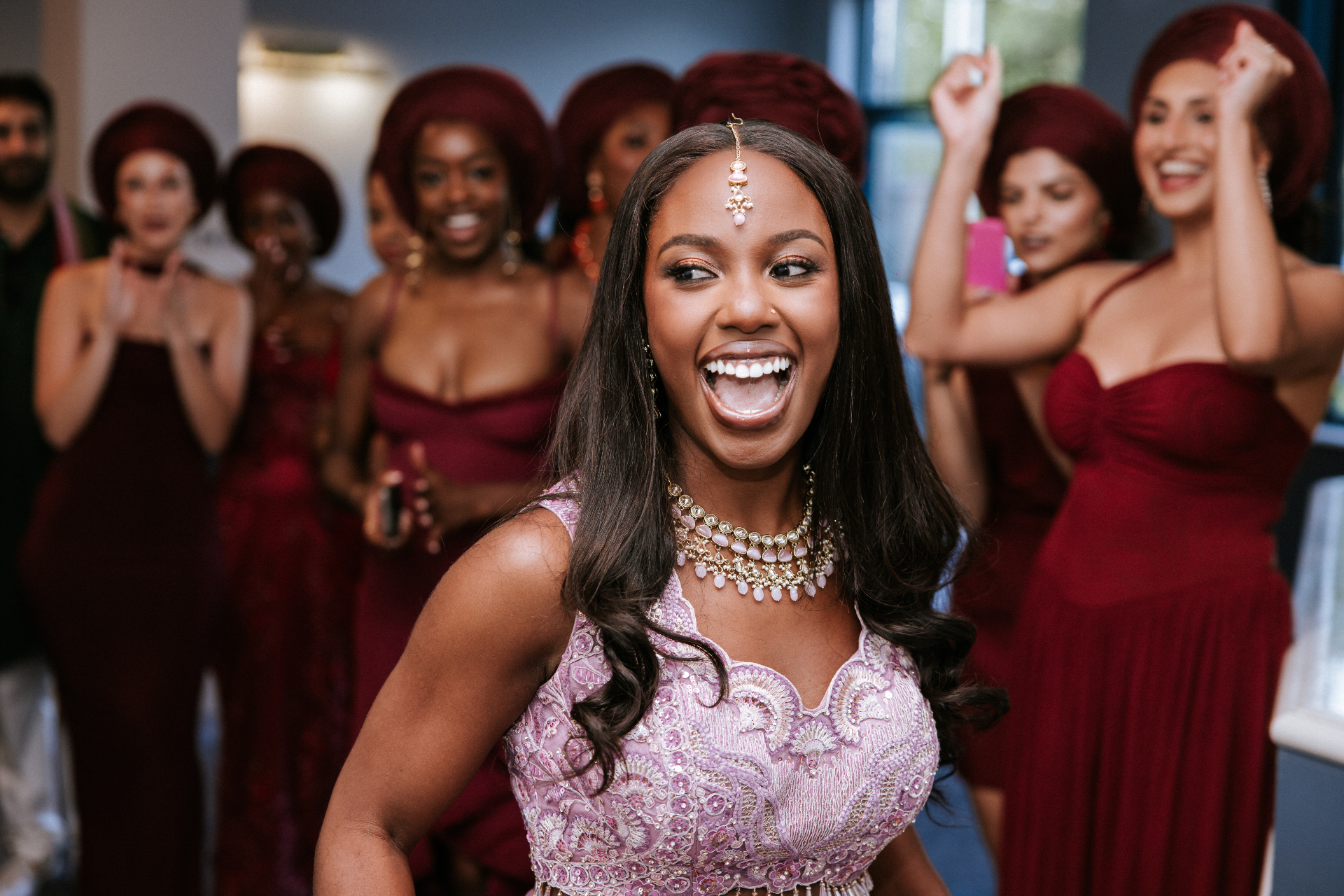 A bride beaming with joy, surrounded by her cheering bridal party